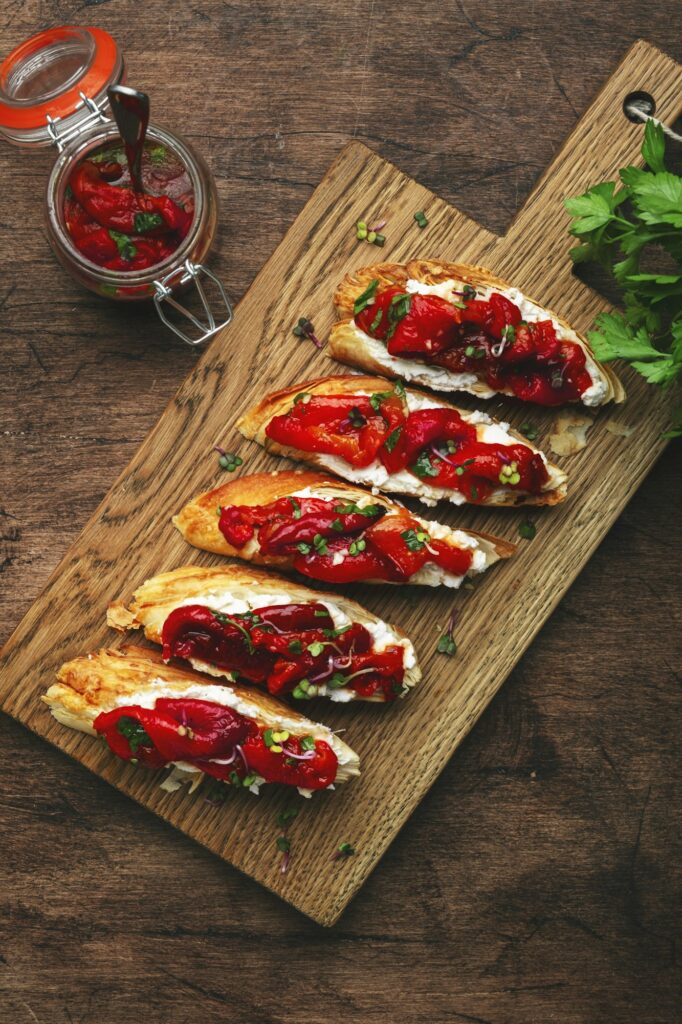 Crunchy bruschetta with soft cream cheese and sweet red paprika in olive oil